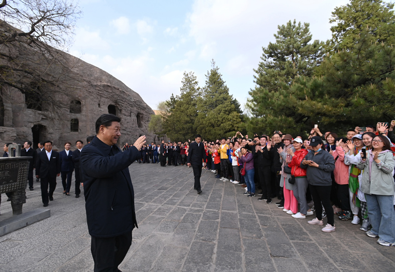 5月11日至12日，中共中央总书记、国家主席、中央军委主席习近平在山西考察。这是5月11日下午，习近平在大同市云冈石窟考察时，向游客们挥手致意。新华社记者 李学仁 摄